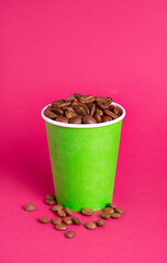 Fototapeta na wymiar coffee beans in a green glass on a red background