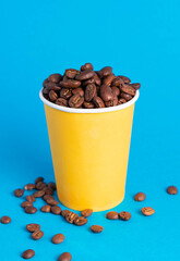 coffee beans in a yellow glass on a blue background