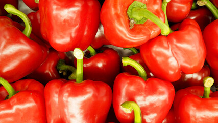 a lot of large sweet peppers lies in a box, top view