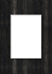 Black picture frame hanging on a black wooden wall