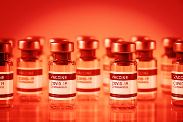 Covid-19 vaccine bottles on a red background