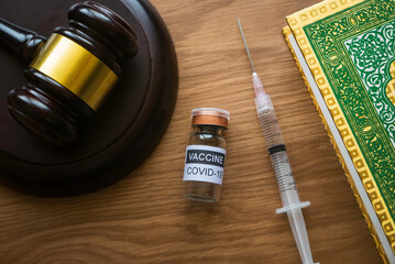 Sharia law and vaccination concept. Selective focus of bottle of covid-19 vaccine, gavel and...