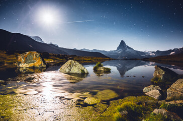 Famous peak Matterhorn (Cervino) under the starry sky. Location place Stellisee, Switzerland, Swiss alps, Europe.