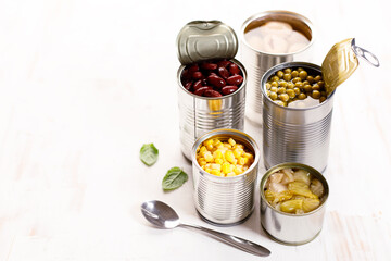 Various canned vegetables on kitchen table background.