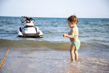 Fototapeta na wymiar cute toddler kid standing on the seashore rear view