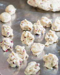 Raw dough balls with cranberries for baking cookies