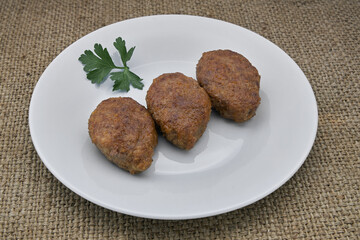 Cutlets on a white plate on the table