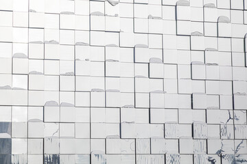 An abstract background of glass or metal squares of the wall glareing at light.