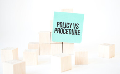Text POLICY VS PROCEDURE writing in green card cube ladder. White background. Business concept