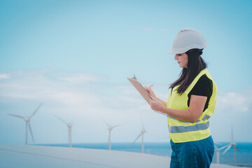 adult female engineer supervises solar panels and windmills in a renewable energy complex