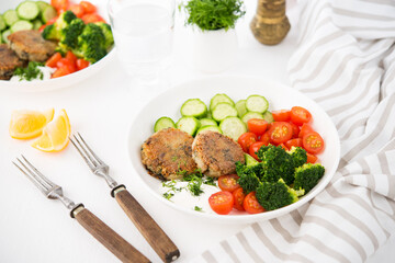 Vegetarian dish of potato patties with herbs and vegetables in a plate