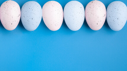 Easter banner, eggs on blue background in pastel colors, egg hunt, party, spring holiday concept