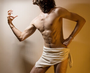 Young long haired male standing in dramatic, theatrical pose