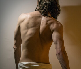 Back muscles of long haired male model, dramatic lighting
