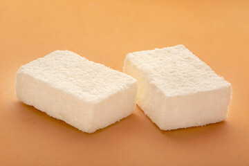 Candy in coconut flakes on a colored background