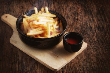 French fries with ketchup on a dark wood background. fastfood snack.