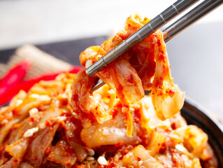 Korean food, Cabbage kimchi in black dish set on dark background.