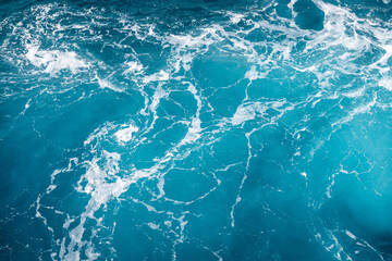 Natural background of blue foaming sea water.