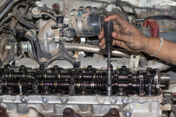 The mechanic is checking the engine.