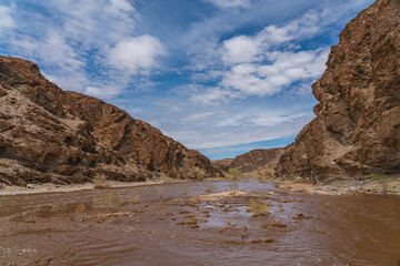 Fototapeta na wymiar Gaub river in Namibia with much water after heavy rainfalls, Namib Naukluft Park, background cloudy sky