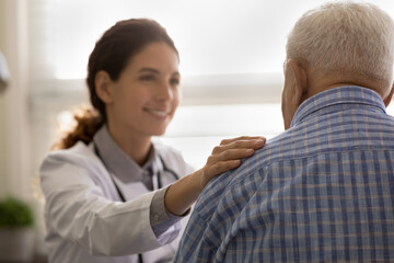 Close up focus on hand smiling female doctor touching old patient shoulder, comforting, good news, medical checkup results, physician therapist expressing empathy, psychological help concept