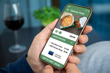 male hands hold phone with food delivery application background room