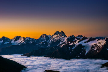 Snowy Greater Caucasus ridge with the Mt. Ushba at vibrant summer sunrise. View from 