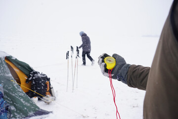 Big beautiful yellow compass in hand. A traveler holds a gloved compass at the north pole in winter. Compass on a winter expedition