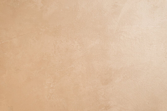 walls are decorated with Venetian decorative plaster with a golden tint of paint. Background, abstraction. The concept of apartment renovation. copy space