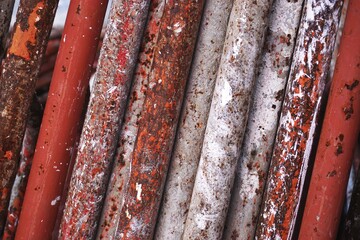 Closeup detail of rusty paint-splattered scaffold pipes abstract horizontal background pattern