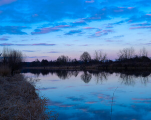 The reflection of colorful clouds in the water after sunset
