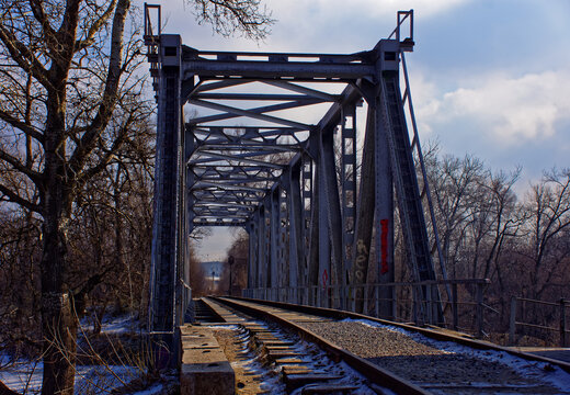 an abandoned railway bridge over a frozen river