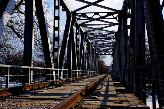 an abandoned railway bridge over a frozen river