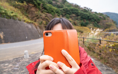 スマートフォンで写真撮影をしている女性の写真