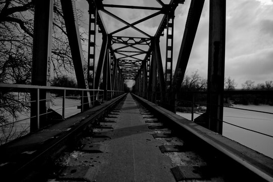 an abandoned railway bridge over a frozen river