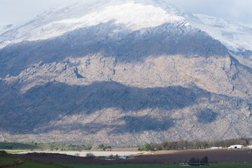 Winter agricultural landscape scenic view of a snow capped mountain and lake in Ceres, Western...