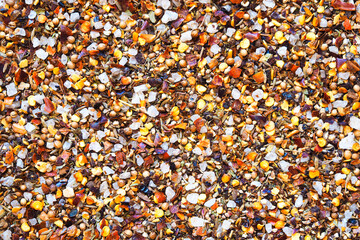 Spices and seasoning background. Black peppercorns, paprika, coriander, garlic, sea salt, satureja, basil, chili pepper. Seasoning for meat dishes