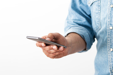 Cropped shot of an unrecognizable businessman standing alone in his home office and texting on his cellphone