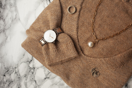 Lifestyle And Fashion Flat Lay: Clothes And Rose Gold Jewelry On Marble Background: Sweater, Jewellery, Watches