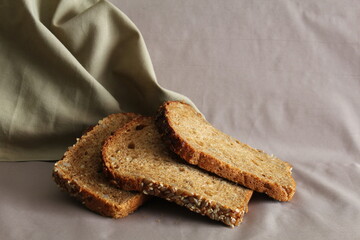 Pieces of bread with cereals on a blurred background.