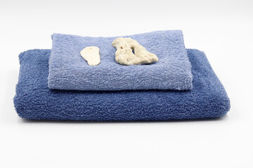 set consisting of blue towel with candle plant and stones.
