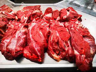 hearty fresh chopped and chopped natural fillets of raw beef and lamb are spread out on the counter in a butcher shop in a large food market