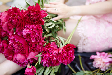 Woman holds a bouquet of peonies. Bright festive mood