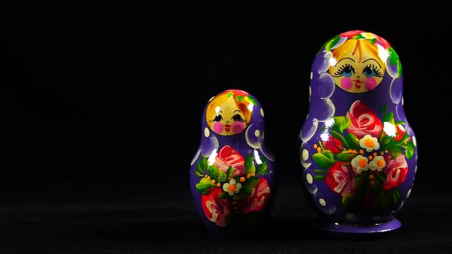 nesting dolls on a black background. Matryoshka - Russian folding doll made of wood, inside which there are dolls of smaller size. Retro