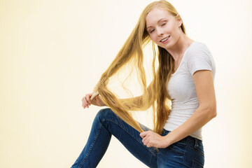 Blonde girl brushing her long hair