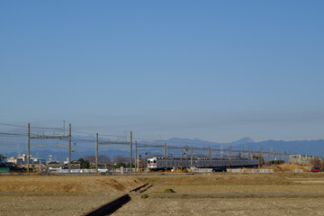 Fototapeta premium 小江戸川越 外秩父連峰をバックに東武東上線に列車が走り抜ける