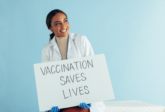 Doctor with "Vaccination saves lives" banner