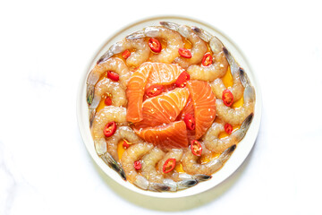Pickled shrimp and salmon with soy sauce on marble table background with copy space for text or recipe.