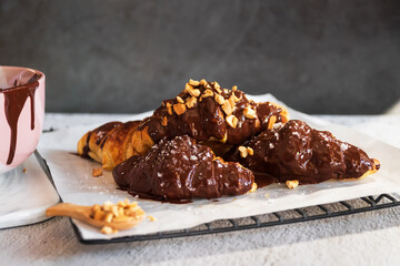Dark chocolate croissants with nut and flower of salt on top in vintage dark stone background. Tasty and freshly croissants. 
