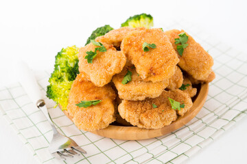 Homemade chicken nuggets with vegetables (broccoli) in a plate on a white background